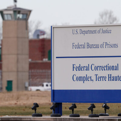A guard tower flanks the sign at the entrance to the U.S. Penitentiary in Terre Haute.