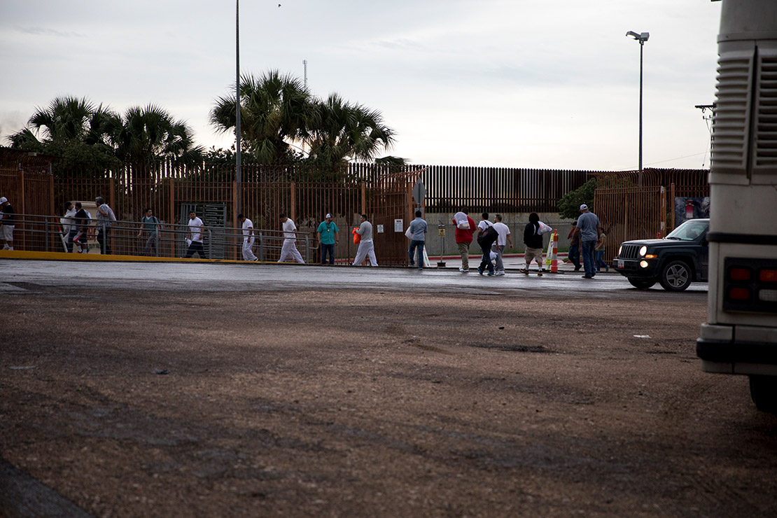 A line of individuals at the U.S.-Mexico border.