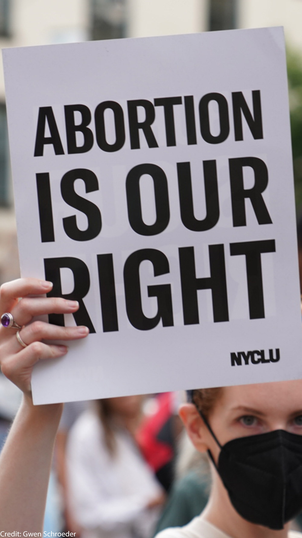 A demonstrator holding a sign that says Abortion is Our Right.