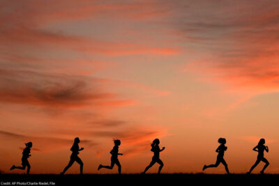 A silhouette of a line of runners.