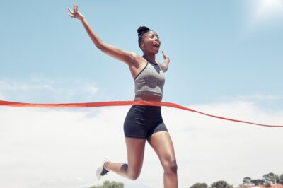 Black girl runner crossing the red victory ribbon